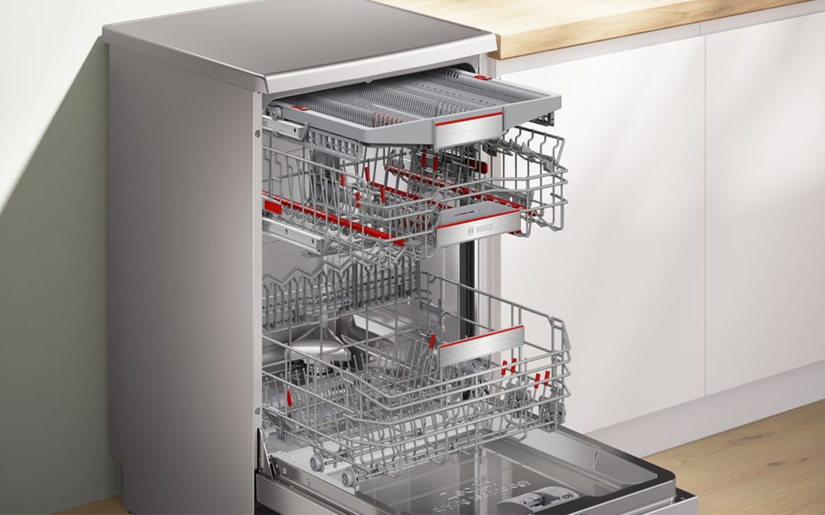 Bosch stainless steel dishwasher with an open door displaying clean dishes neatly arranged on adjustable racks.