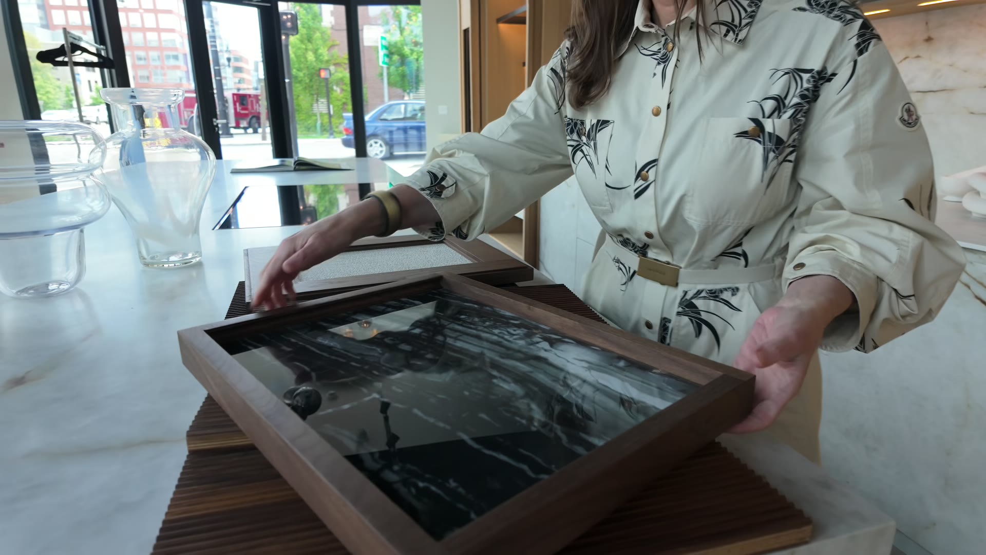 A dark stone sample lifted from a material tray in the DOCA Boston showroom