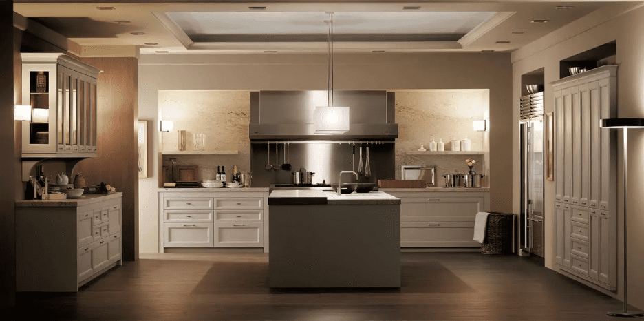 Conventional showroom kitchen with beige cabinetry, a stainless hood and a central island