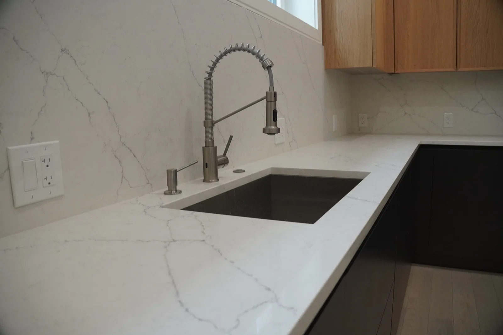 Close view of a porcelain kitchen backsplash and integrated sink