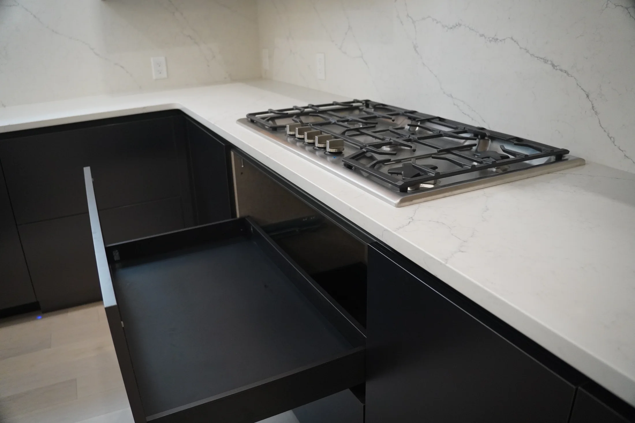 Deep dark drawers opened beneath the cooktop