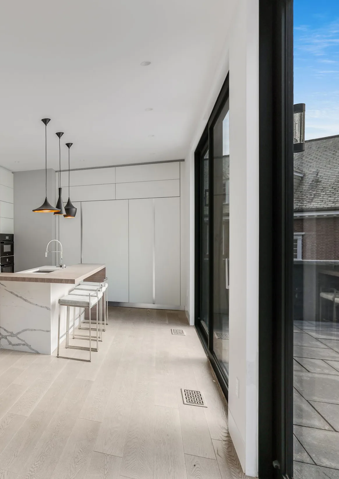 Wellesley kitchen with stained oak details, white cabinetry and a marble island