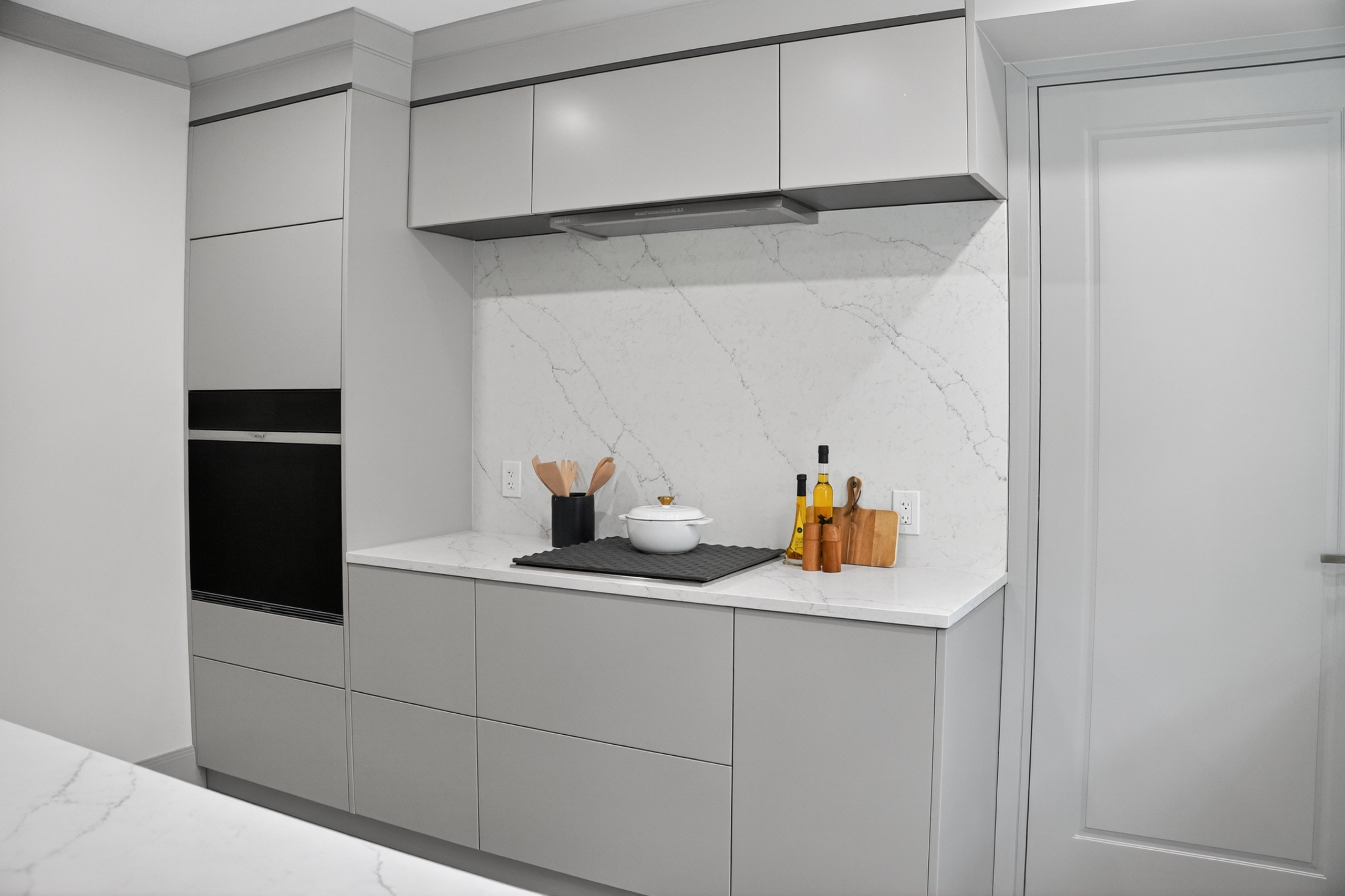 Gray cooktop cabinetry and pale veined backsplash on Clinton Road