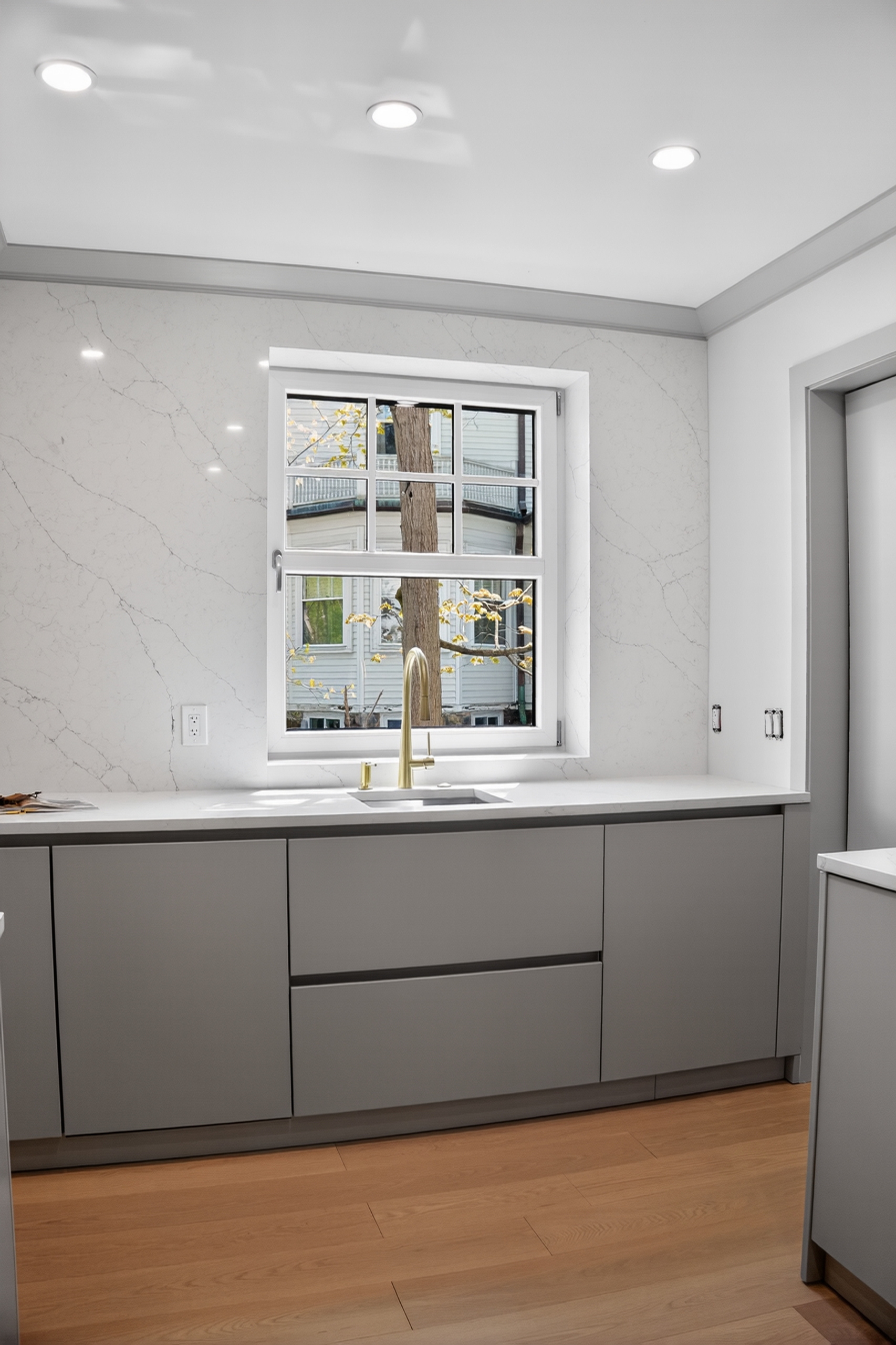 Gray cabinetry below a window in the Clinton Road kitchen