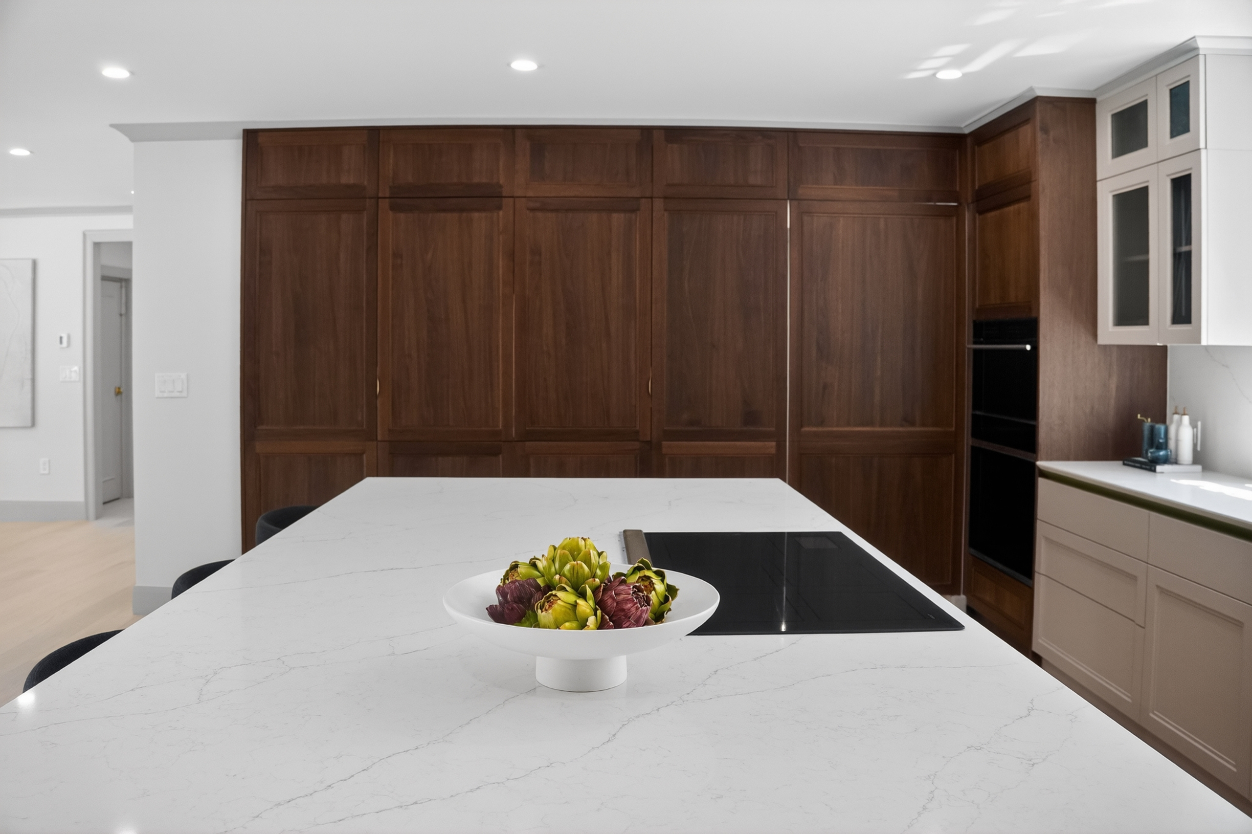 Pale veined island in front of dark wood kitchen cabinetry on Clinton Road