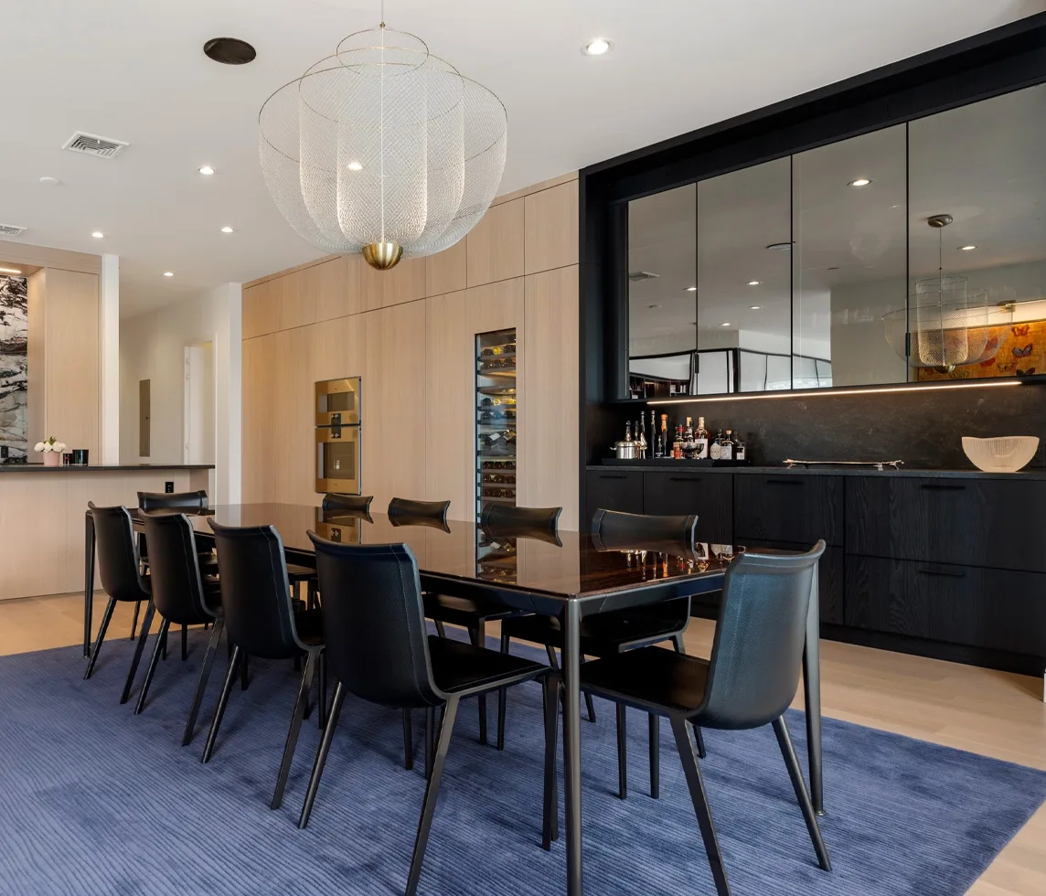 Dining area with glass partition, pale oak cabinetry and charcoal details in Boston