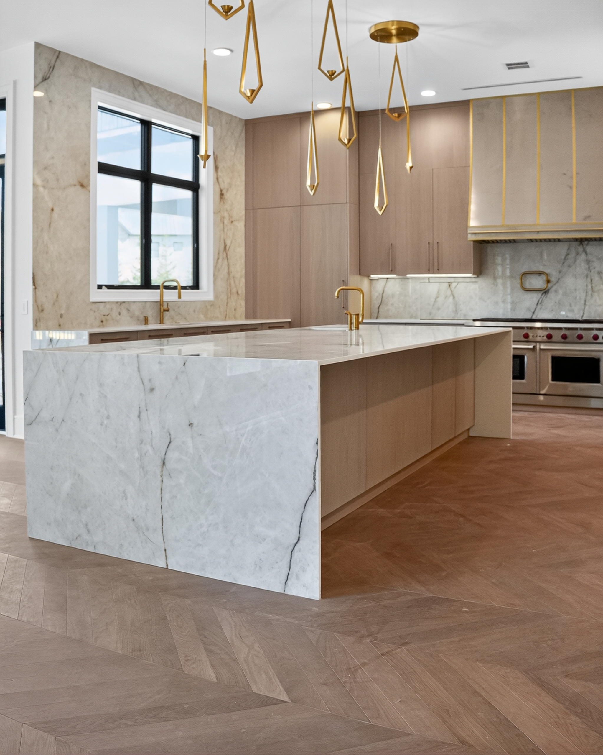 Veined stone island, brass-toned pendants and warm wood cabinetry in the luxury new build