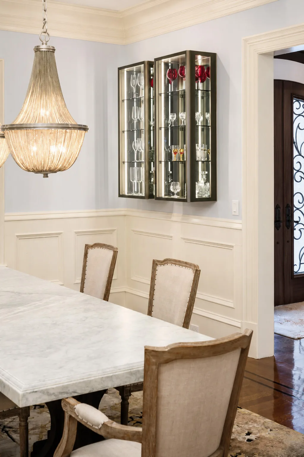 Glass display cabinetry and mirrored interiors in a traditional Newton dining room